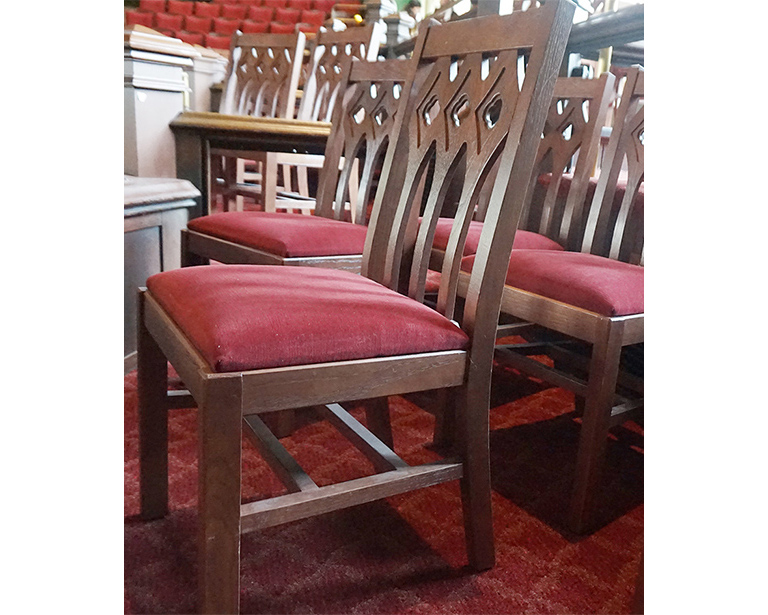 Gothic style wood chair with upholstered seat in chapel